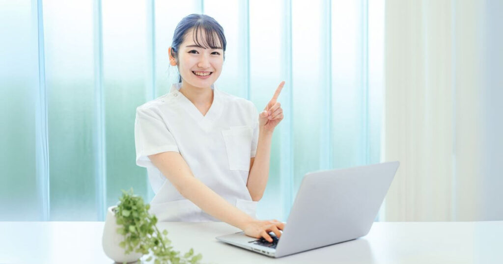 歯科医師がパソコンを使いながら質問に答える様子