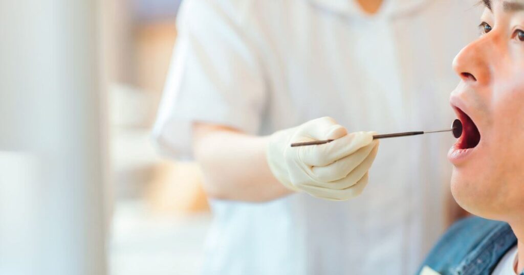 歯科医院で診察を受ける男性患者と治療器具